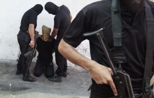 Hamas militants grab a Palestinian suspected of collaborating with Israel in Gaza City